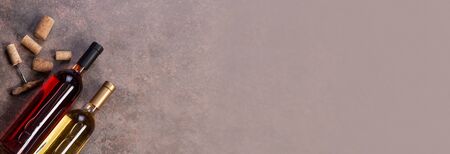 Red and white wine  bottles on stone background. Top view with copy spaceの写真素材