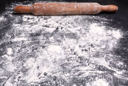 Baking background with the rolling pin with flour. On the dark table. Free space for textの写真素材
