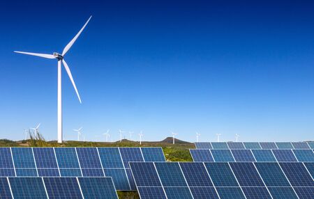 solar panels with wind turbines  against blue sky の写真素材