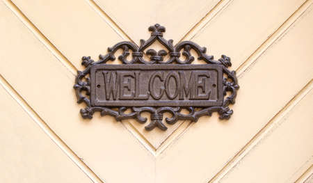 metal welcome sign on wooden background; copy spaceの写真素材