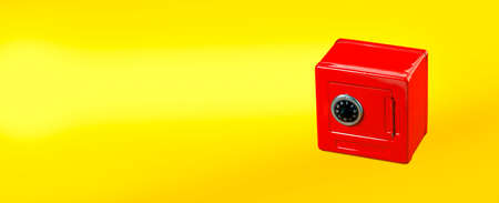 Red moneybox (piggy bank) made as safe. on yellow background with copy spaceの写真素材