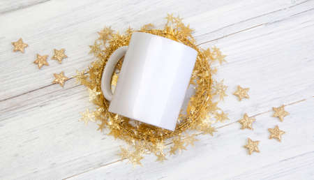 white mug cup holiday mockup. Gold Stars wooden background. Christmas giftsの写真素材