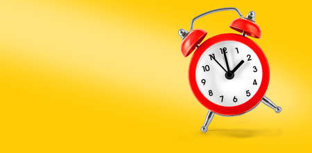 Red retro alarm clock on Yellow background