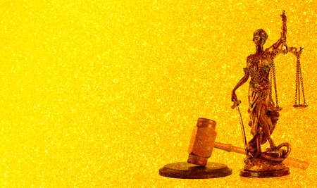 Themis statue, symbol of law and justice on gold glitter texture