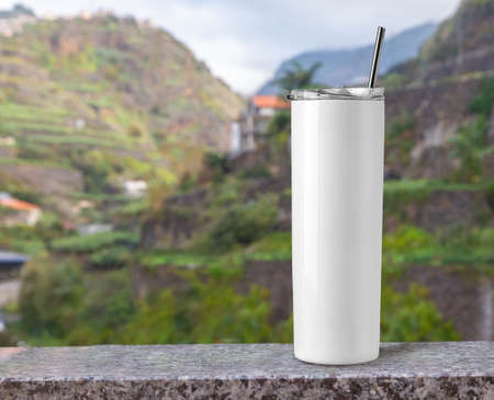 Blank Stainless Steel Tumbler with Lid for branding mock up. on stone table in the tropical background.の写真素材