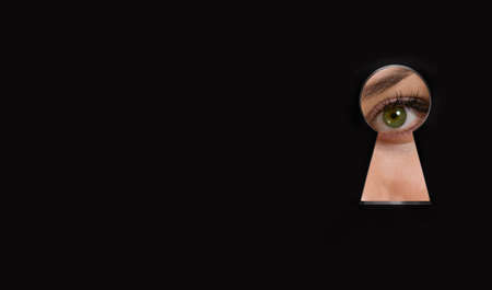 Abstract keyhole opening with eye on black background. access and vision concept