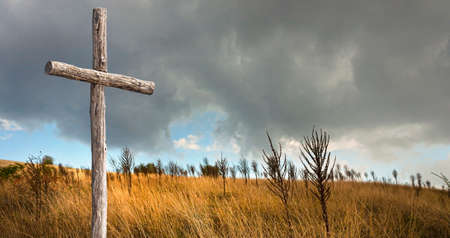 a lonely wooden cross on an autumn fieldの写真素材