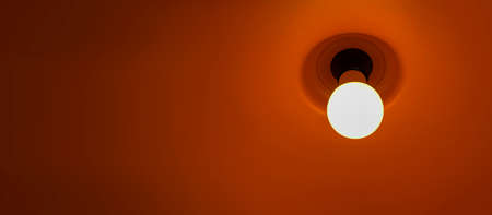 lit energy-saving lamp close-up background with copy spaceの写真素材