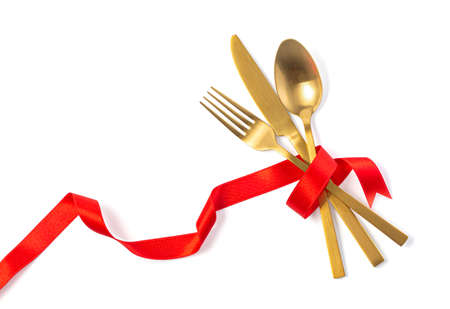 Cutlery tied with red ribbon on white backgroundの写真素材