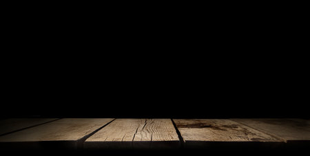 Wooden table on black wall in dark room background for product montageの写真素材