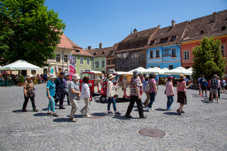 Sighisoara, Romania June 09, 2019: A group of tourists in the center of the old town of Sighisoara in Transylvania, Romaniaのeditorial素材