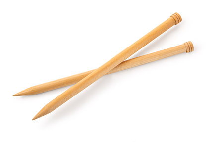 A pair of large wooden knitting needles from low perspective isolated against white background.のeditorial素材