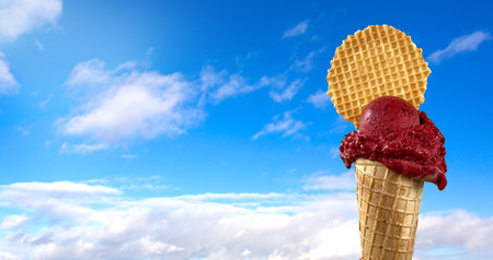 Ice cream cone on blue sky background with copy space