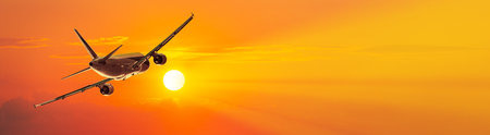 The plane takes off at sunset with panoramic background and copy spaceの写真素材