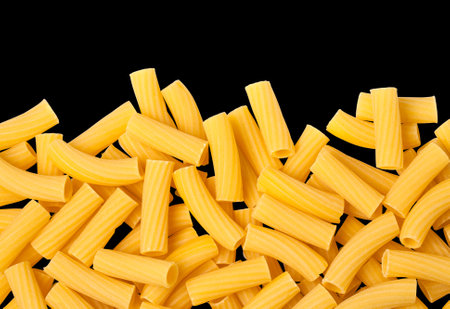 tortiglioni raw pasta isolated on black background with clipping pathの写真素材