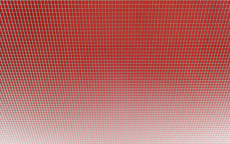 Geometric red background with white grid creating a regular pattern of squaresの写真素材