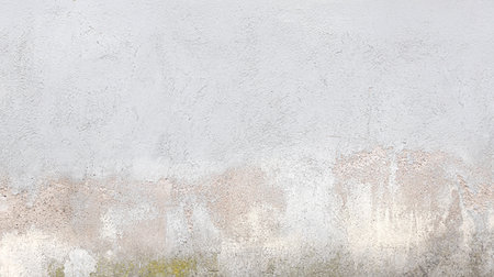 Gray concrete wall with weathered and stained surface, ideal for backgrounds and texturesの写真素材