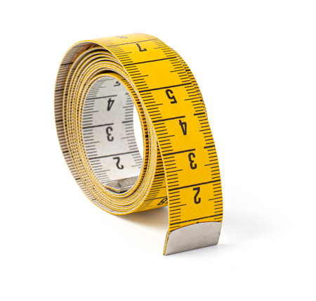 Close-up of curled yellow measuring tape, ideal for projects involving measuring, tailoring, or diy