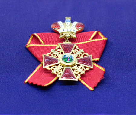 Golden royal order of sahametrei medallion with red ribbon resting on blue velvet background