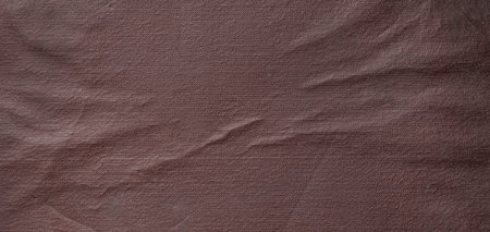 Wrinkled brown fabric forms an abstract background pattern with intricate texture