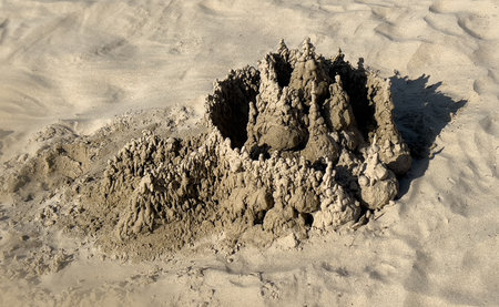 Elaborate sand drip castle sculpture on a sunny beach, showcasing summer fun and creativity