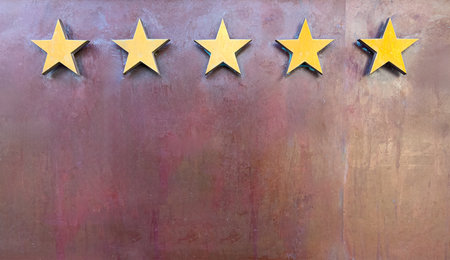 Gold stars on a textured metallic background showing best quality and success