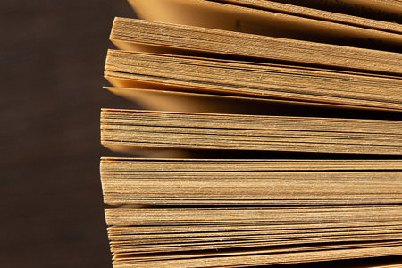 Stacked paper pages of an old book creating a vintage background texture, representing knowledgeの写真素材