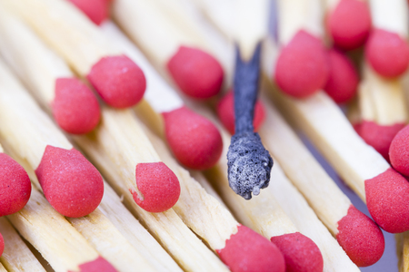 Burnt match stick among unburnt match sticksの写真素材