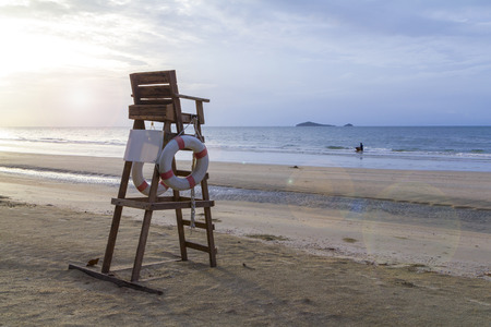 Lifeguard chair on the beach with cloudy sky in the warm morning lightの写真素材