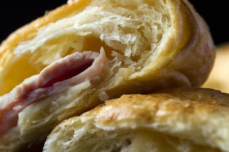 Close-up split butter croissant with ham and cheese sandwiches showing its texture.の写真素材