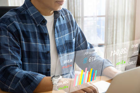 Businessman in casual dress working with notebook computer with futuristic stock exchange virtual...