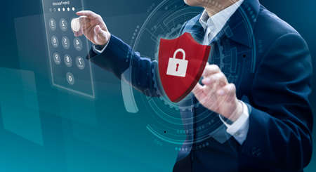 Businessman entering passcode while the other hand holding virtual red metal shield with padlock in system security and data protection concept.の写真素材