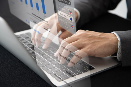 Closeup of businessman's hands typing on a laptop computer for data analysis in business performance...