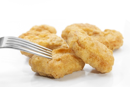 chicken nuggets with fork on white backgroundの写真素材