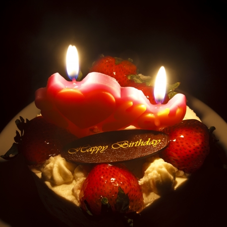 strawberry butter cream cake with  birthday chocolate plate on candlelight feelingの写真素材