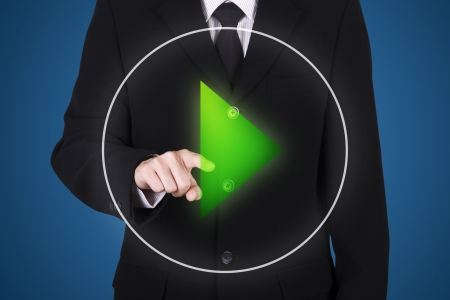 businessman press on start button, blue backgroundの写真素材