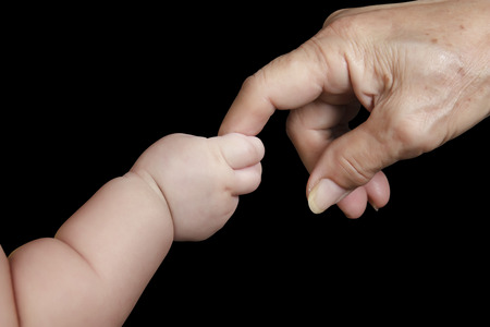 baby and grandmother hand on black, included clipping pathの写真素材