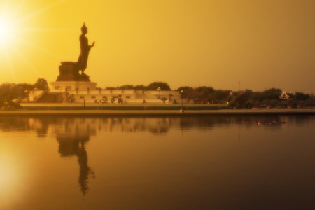 soft filter beautiful landscape silhouette buddha statue sacred with sunset and reflection shadow on the lake and clear sky at phutthamonthon in Thailandの写真素材
