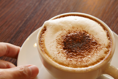 serve fresh hot cappuccino coffee in white cup on wood table in the morning for breakfast drink before work on warm white and nature light at coffee shop or officeの写真素材