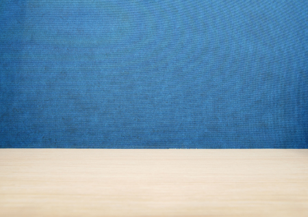 top side 45 degrees view brown wood table or desk with blue texture wall or partition and board background for place your product or object and text on boardの写真素材