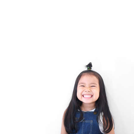 Asian children cute or kid girl and kindergarten student happy smile white teeth and laugh thinking...