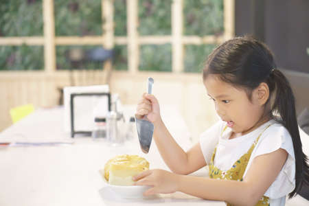 Asian child cute or kid girl smiling and training bread or cake making and cooking in bakery shop on...