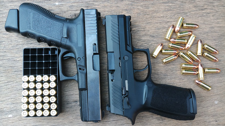 gun and ammunition on wooden background,vintage conceptの写真素材