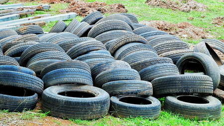 Old tires on the grass prepare for recycling.の写真素材