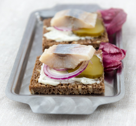 Sandwiches of rye bread with herring, onions and cucumber