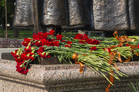 KRASNODAR, RUSSIA - JULY, 29, 2016: Red carnations and St. George ribbons on the unveiling of the "The Cossacks and the Mountaineers - the heroes of the First world war", Krasnodarのeditorial素材