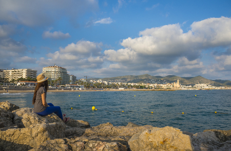 Sitges, Barcelona, Spain - October 01, 2016: The woman on a pier looks at the city of Sitgesのeditorial素材
