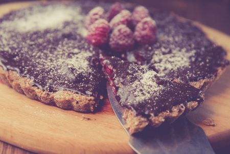 Chocolate tart with melted chocolate filling garnished with raspberryの写真素材
