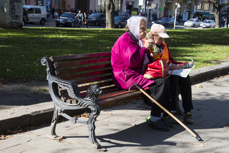 LVIV / UKRAINE - OCTOBER 06, 2018: Two old women rest on a bench, Svobody av. in Lviv cityのeditorial素材