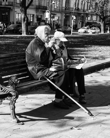 LVIV / UKRAINE - OCTOBER 06, 2018: Two old women rest on a bench, Svobody av. in Lviv cityのeditorial素材